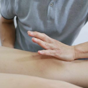 Massage therapist hands treat the knee to the patient on bed Santa Clara Custom Chiro